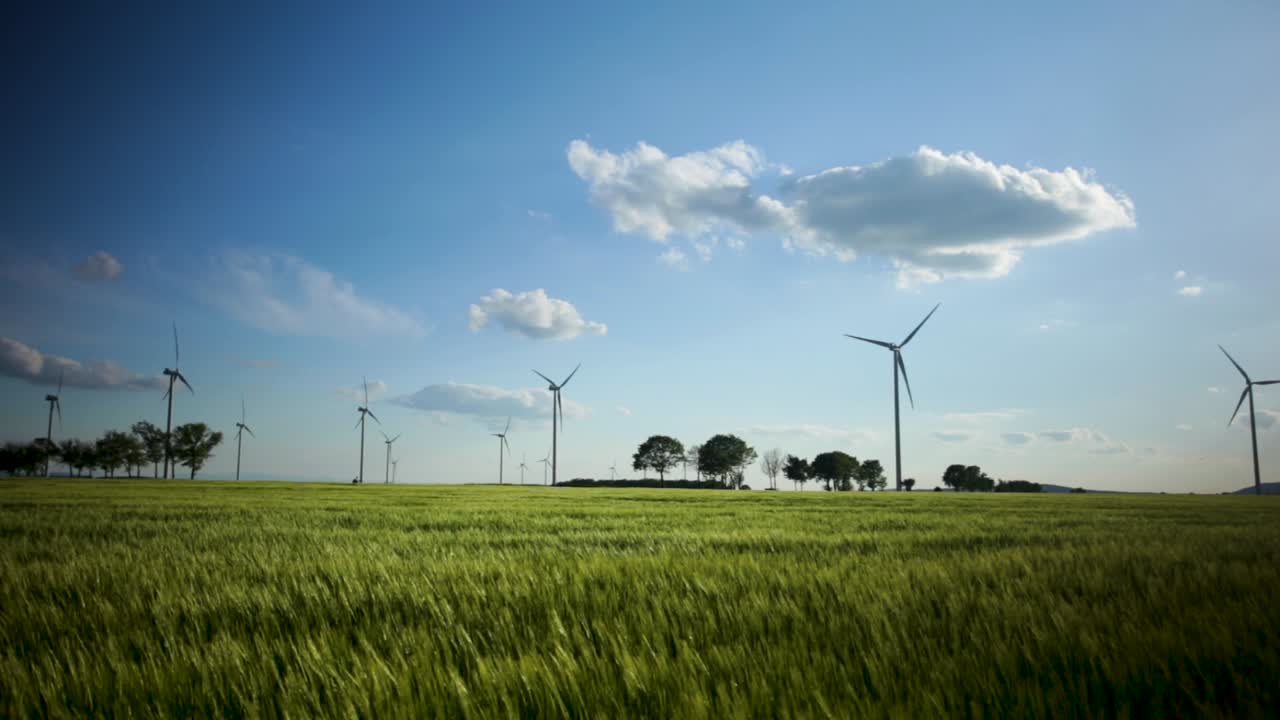 toma panorámica de una granja de molinos de viento, en un campo rural, en un día soleado y ventoso