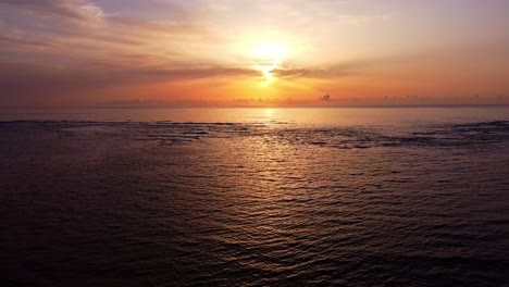 flying over tranquil ocean with dramatic sunset sky in background