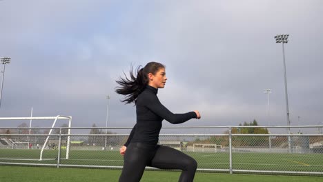 Vista-Lateral-De-La-Niña-Doblando-Las-Rodillas-Y-Saltando,-Entrenamiento-En-Cuclillas-Slomo