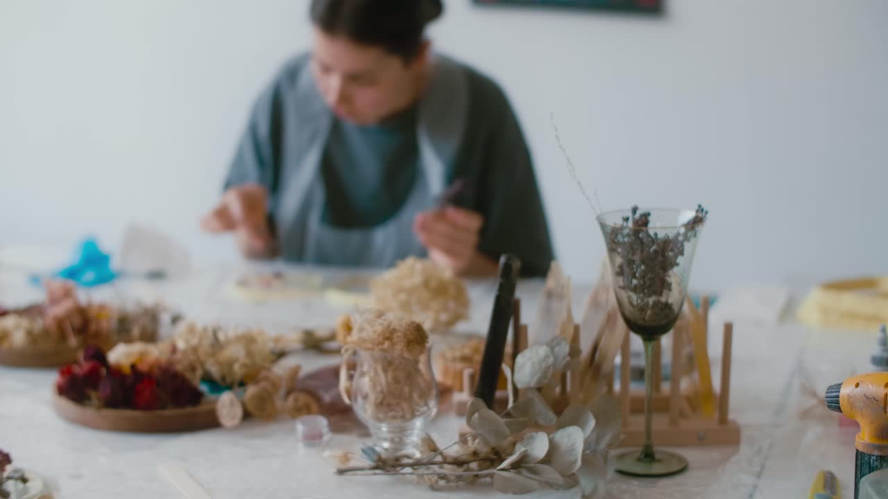 Woman creating dried flower art piece