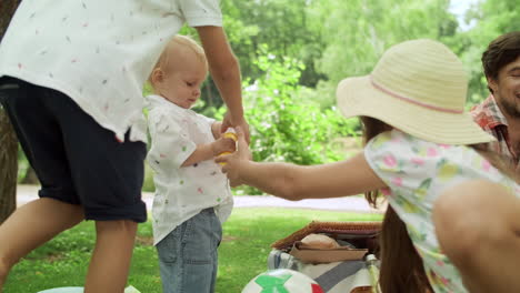 toddler holding bottle with soap bubbles. father and children having picnic