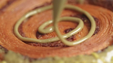 Pistachio-donut-being-decorated-filling-close-up