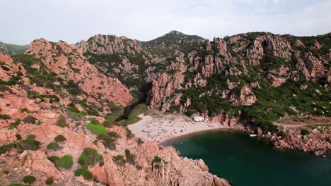 Aerial-view-of-remote-beach-in-a-rock-coast-bay-in-Sardinia,-Italy