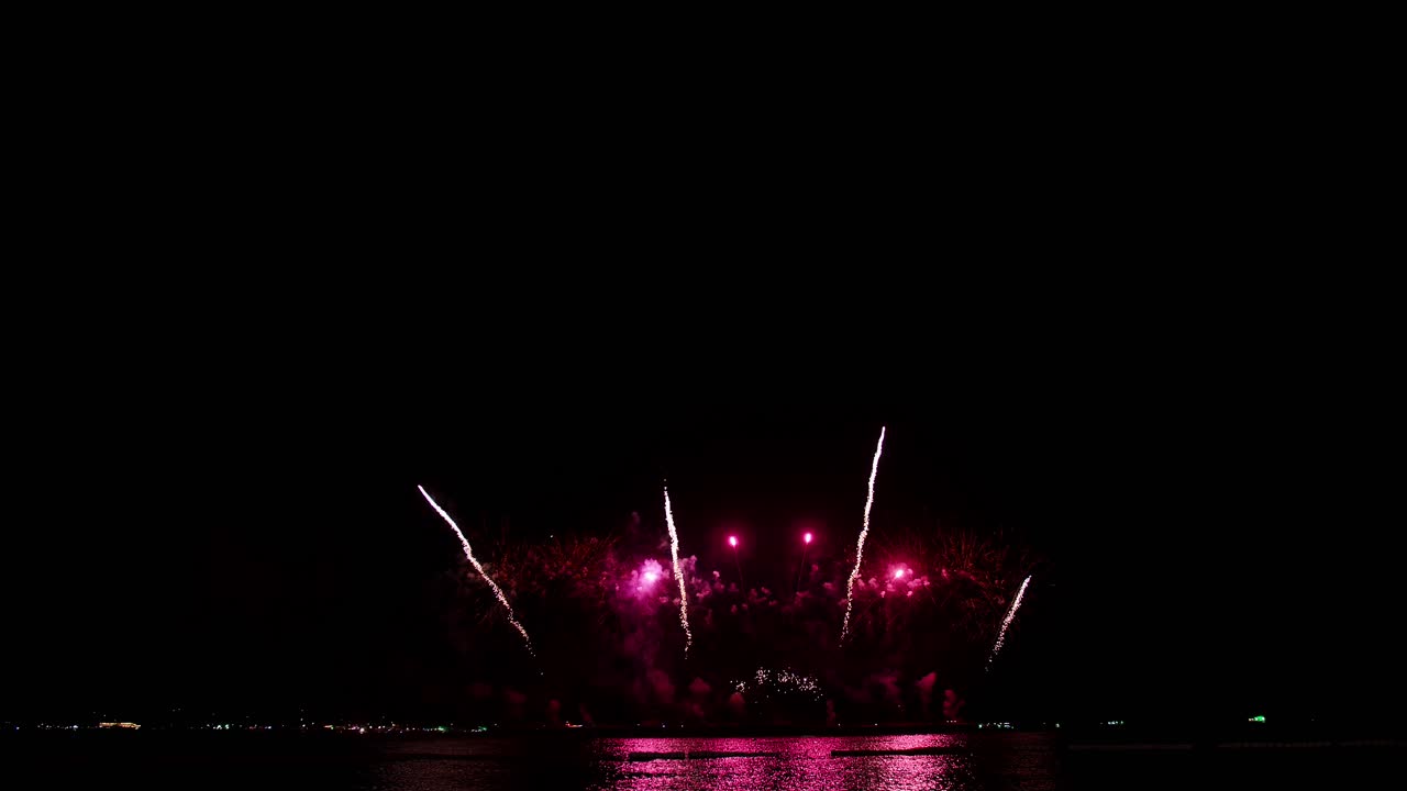 coloridos fuegos artificiales reales celebran la víspera de año nuevo con un desenfoque abstracto de brillo dorado con luces bokeh en el cielo nocturno