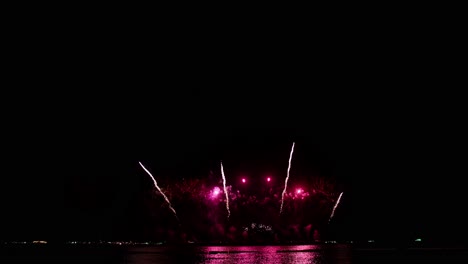 coloridos fuegos artificiales reales celebran la víspera de año nuevo con un desenfoque abstracto de brillo dorado con luces bokeh en el cielo nocturno