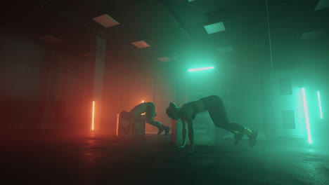 a man and a woman jump over a box performing a burpee. joint teamwork. athletic couple performs cardio workout functional jumping burpee in the gym in neon dark colors