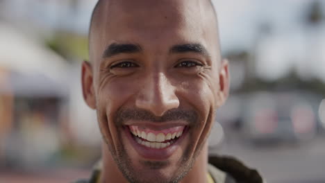 close-up-portrait-of-handsome-hispanic-man-laughing-cheerful-looking-at-camera-happy-enjoying-warm-summer-on-urban-beachfront-street