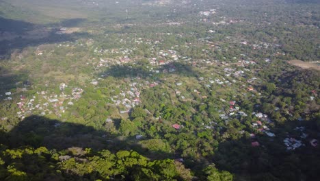 A-quaint-mountain-village,-nestled-among-a-lush-forest,-with-a-beautiful-cityscape-view-in-the-distance