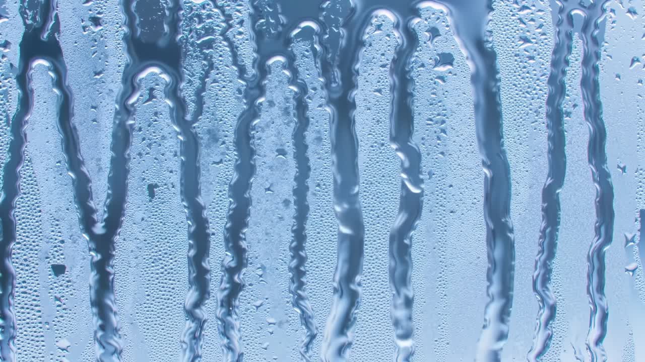 The video captures the gentle movement of water droplets sliding down a cool glass surface, showcasing the beauty of condensation on a hot summer day.