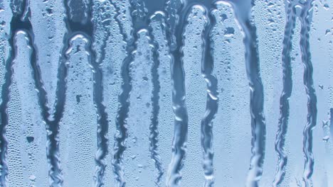 the video captures the gentle movement of water droplets sliding down a cool glass surface, showcasing the beauty of condensation on a hot summer day.