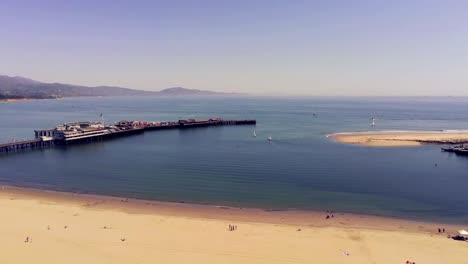 un vuelo de drones sobre una playa adyacente a un muelle, santa barbara california