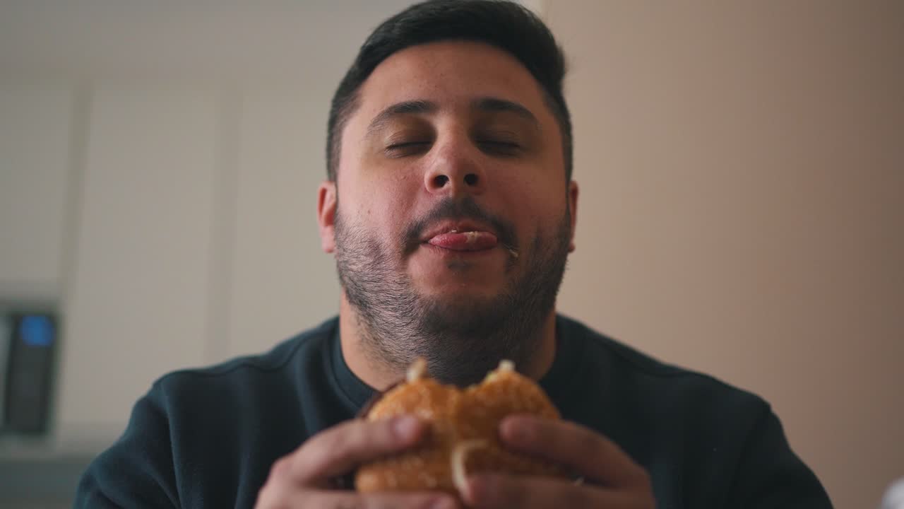 aliviado joven hambriento comiendo una hamburguesa