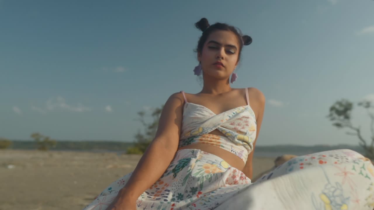 joven dama adulta mujer hipster gen z chica adolescente rostro serio con cabello en nudos y nariz perforación usando pendientes mirando a la cámara posando en la playa, cabeza soleada retrato del cuerpo