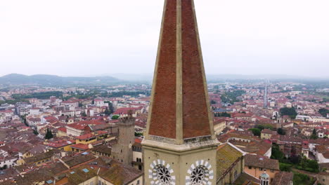 drone orbiting on the iconic bell tower of arezzo cathedral overlooking cityscape in tuscany, italy