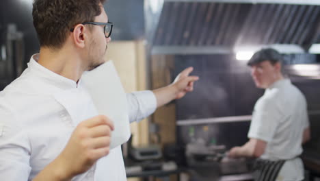 chef cooperating with colleague at work in restaurant kitchen