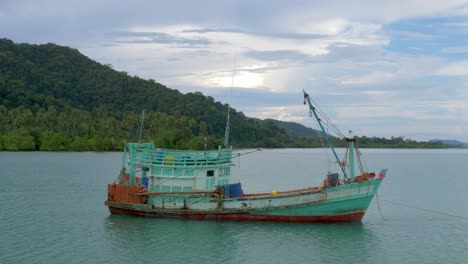 Eine-Statische-Aufnahme-Eines-Alten-Fischerbootes,-Das-In-Der-Nähe-Einer-Insel-Im-Meer-Verankert-Ist