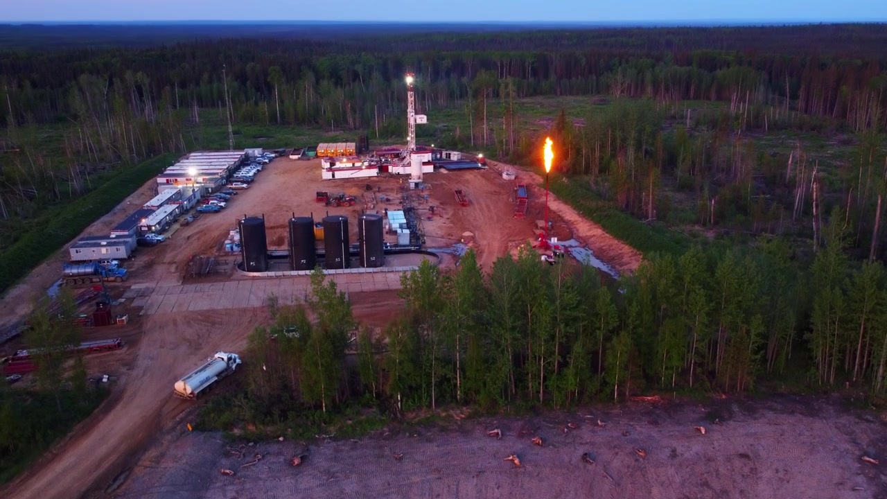 Stigende droneoptagelse af et boreområde med lyserød himmel og solnedgangslys, Alberta, Canada.