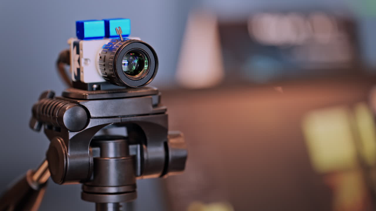 Close up of a professional camera filming on a tripod on a blurred background