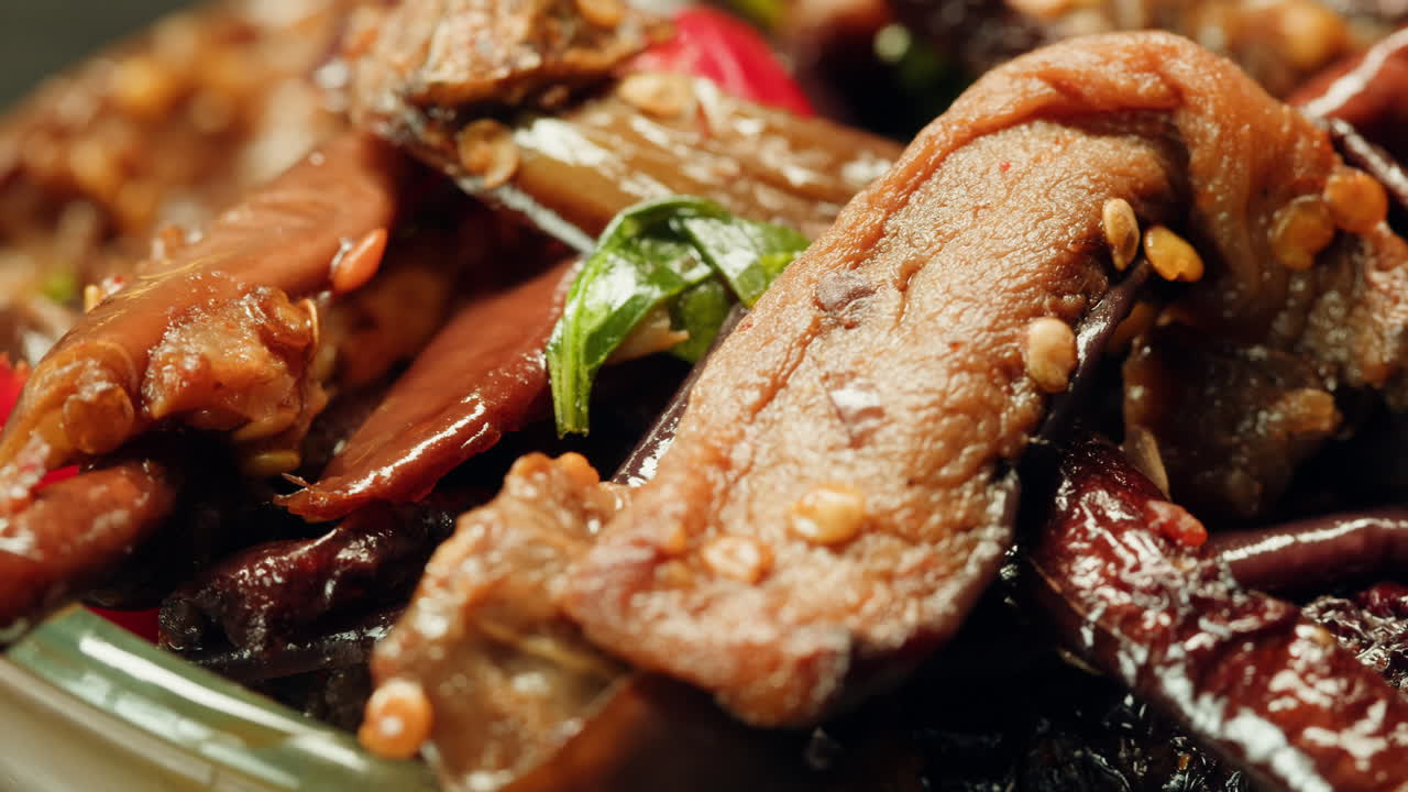 Close-up of fermented eggplants with red sweet pepper and mustard on plate. Preservation of vegetables in glass jars. Fermentation preserved aubergine with hot chilli peppers and greens.