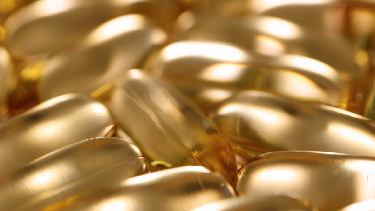 Molte capsule di gelatina di olio di pesce gialle filmato 4K