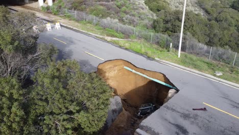 se forma un gran agujero en el fregadero en la carretera