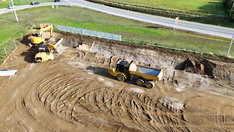 drone captures excavator and dump truck at work on a sunny day in cromwell, showcasing earthmoving activities