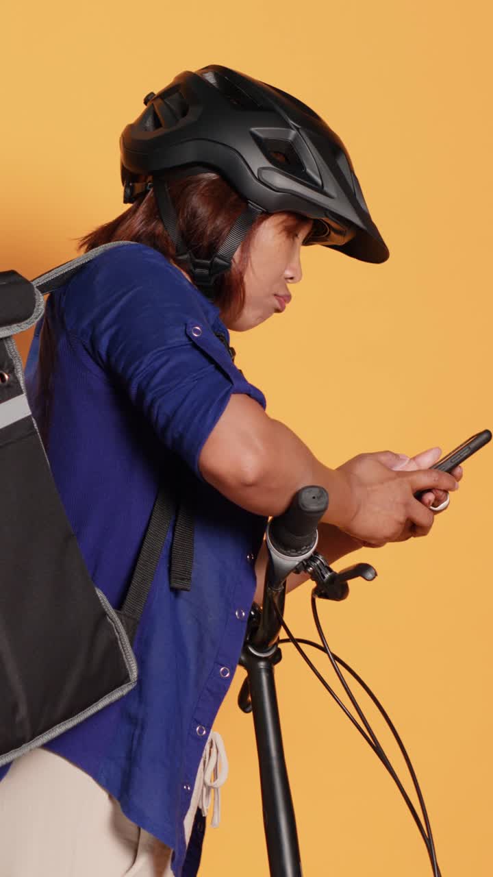 Woman cyclist using smartphone