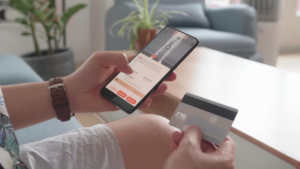 Close Up Of Man Hand Holding Smartphone And Credit Card And Doing Online Shopping At Home