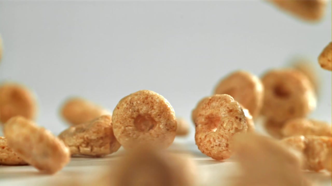 Anéis de Cereal Dourados Caindo em Câmera Lenta