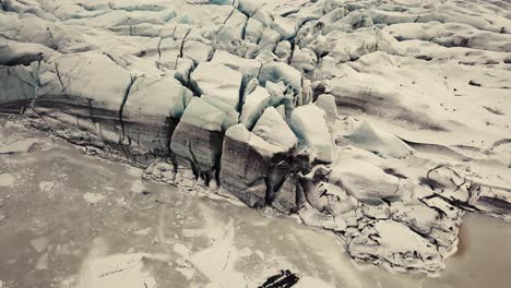 Glacier-tongue-in-Iceland-filmed-by-drone-with-different-cinematic-movements,-showing-a-cloudy,-dramatic-concept-in-wintery-conditions