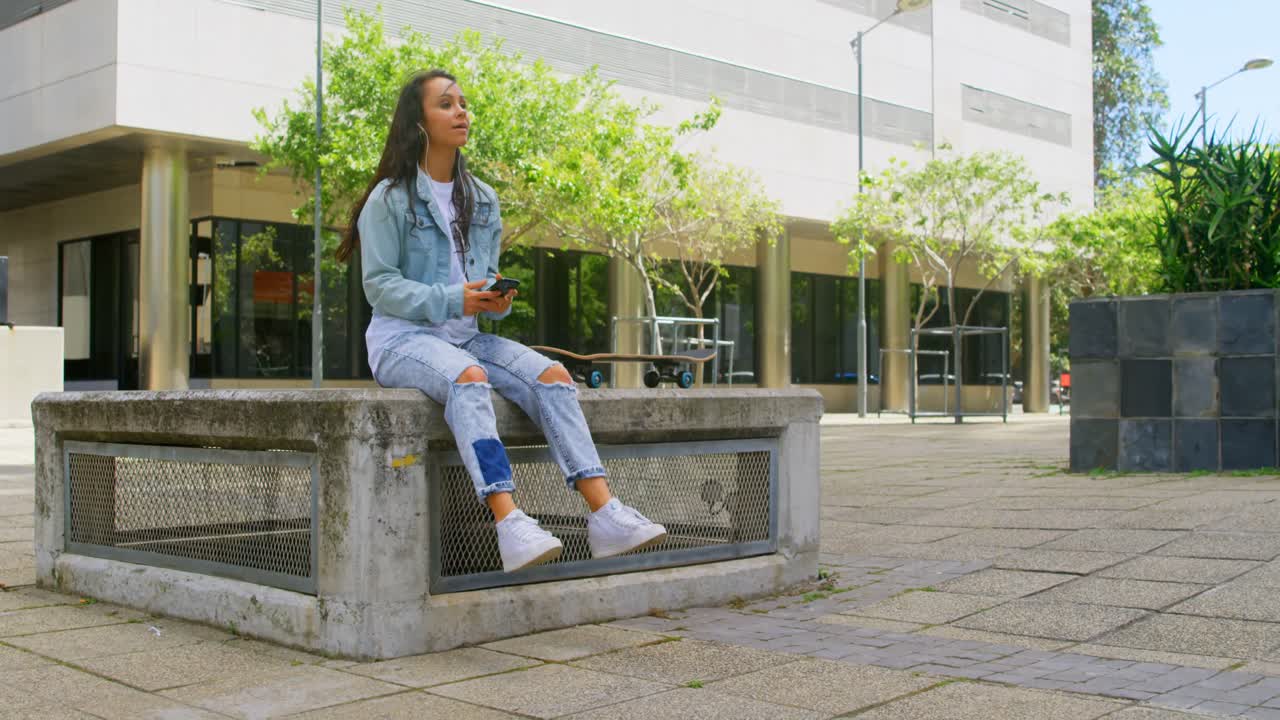 휴대 전화 4k 4k에서 음악을 듣는 스케이트 보드를 가진 무모한 여성