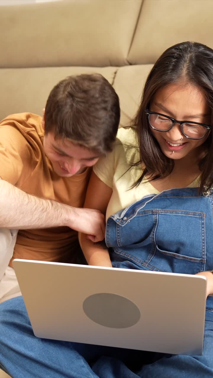 Couple using laptop together indoors