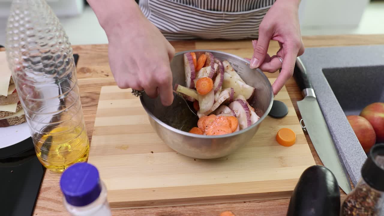 Hands mixing chopped vegetables in a bowl for a healthy meal