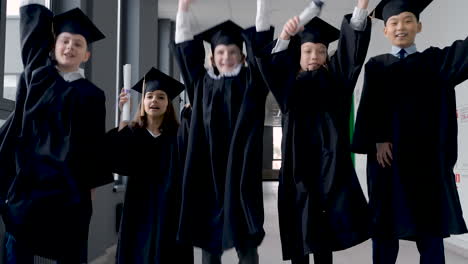 group of happy  preschool students in mortarboard and gown 5