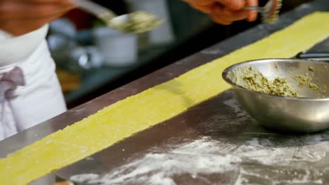 panadero masculino poniendo ingredientes en la masa de pasta 4k