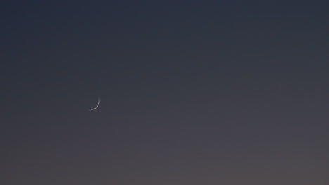 crescent moon setting during the daytime