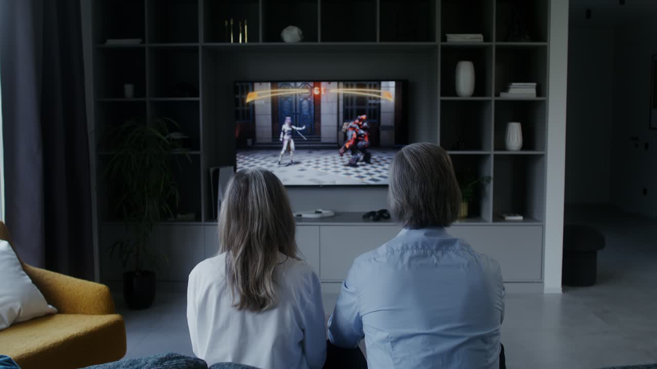 Coppia che guarda un gioco di combattimento in TV