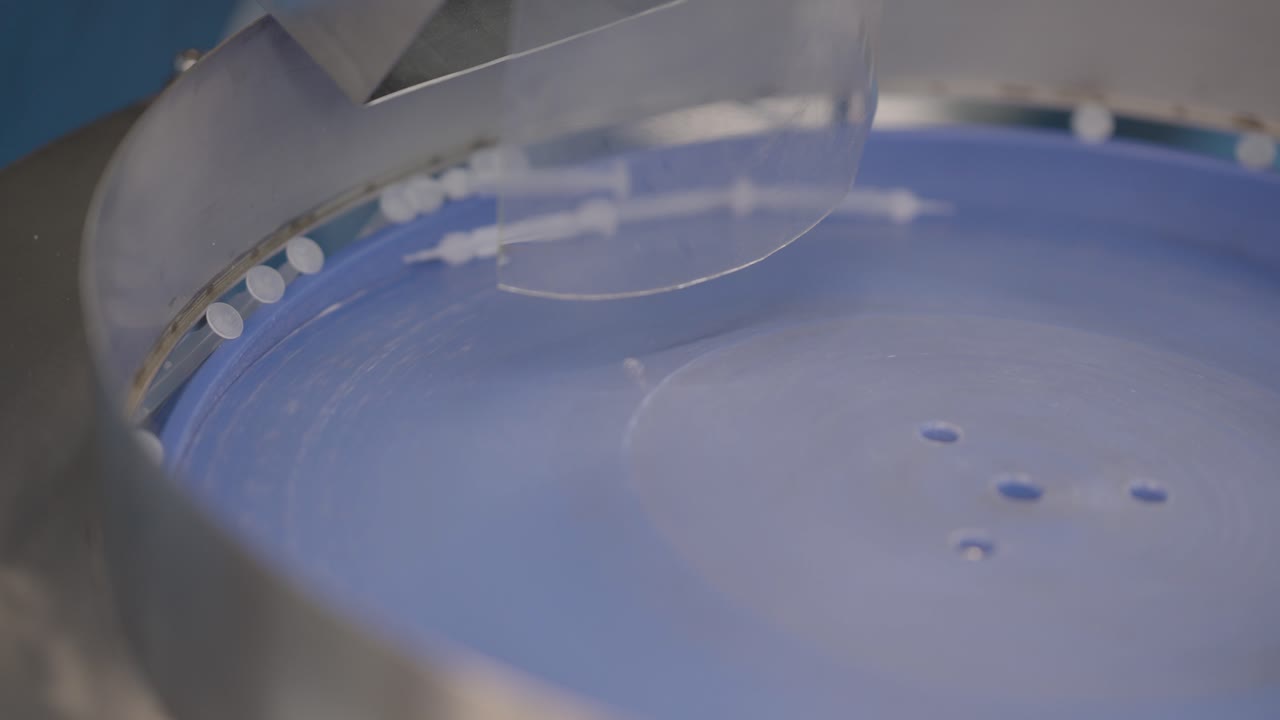Assembled Medical Syringes Dropping Into A Industrial Machine During The Manufacturing Process