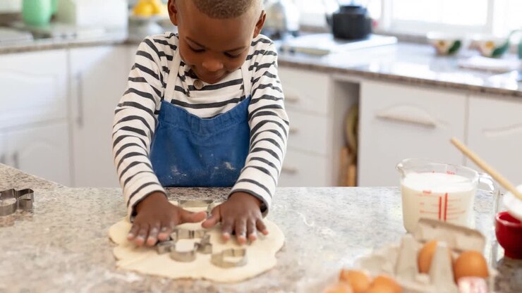 Animation of african american boy preparing cookies in kitchen
