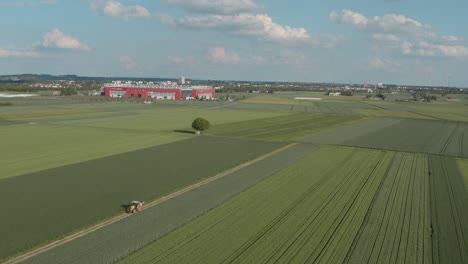 Drone---Aerial-shot-of-the-football-stadium-of-the-bundesliga-team-Mainz-05-with-field-and-a-tractor-in-the-foreground-on-a-sunny-day,-30p