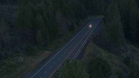 drone shot of emergency fire vehicle driving on highway next to river at night