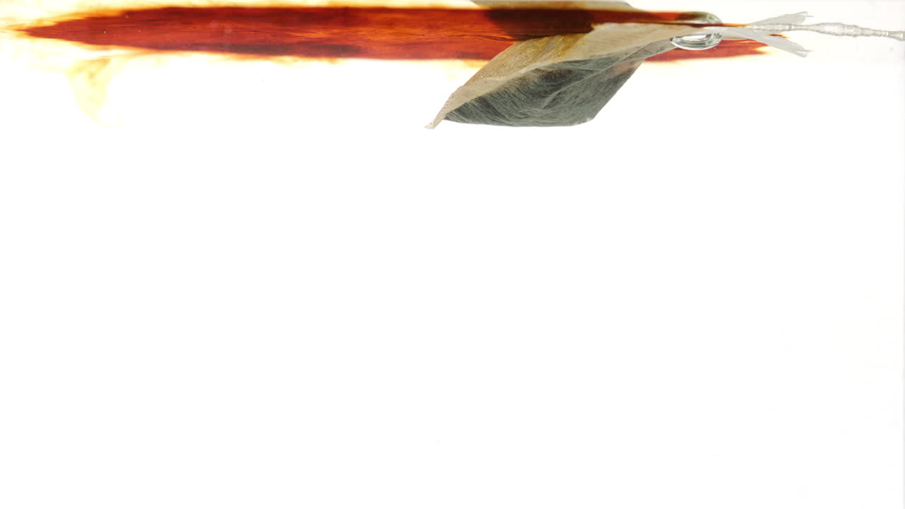 коричневый цвет вытекает из чайных пакетов в горячей кипящей воде