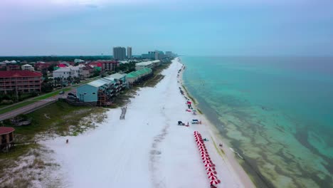 drone view flying up the beautiful white sand beach in miramar near destin florida with great views of the gulf of mexico