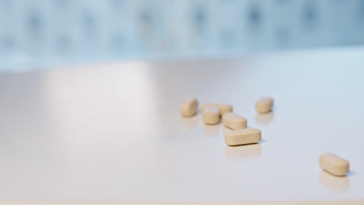 Vitamin tablets falling down on white surface table and bouncing around, Shallow depth and motion blur