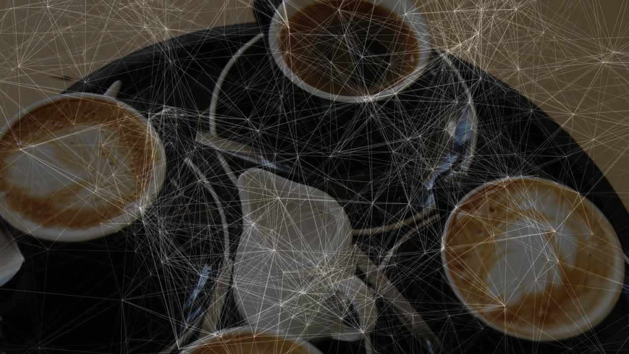 Overhead cafe scene being animated in flat design, featuring four cappuccino cups and metal spoons