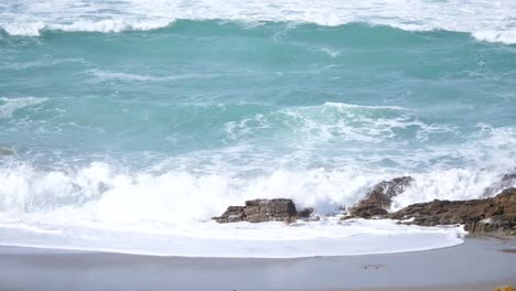 The-waves-in-the-sea-crash-into-the-rocks-at-the-beach