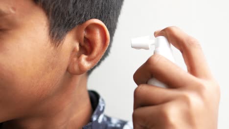 Close-up-of-men-using-spray-to-remove-earwax