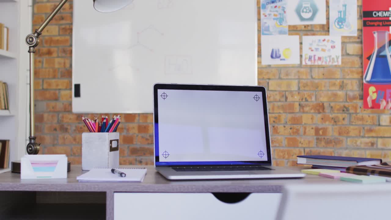 vista de la computadora portátil y otros suministros escolares en la mesa en el aula de la escuela