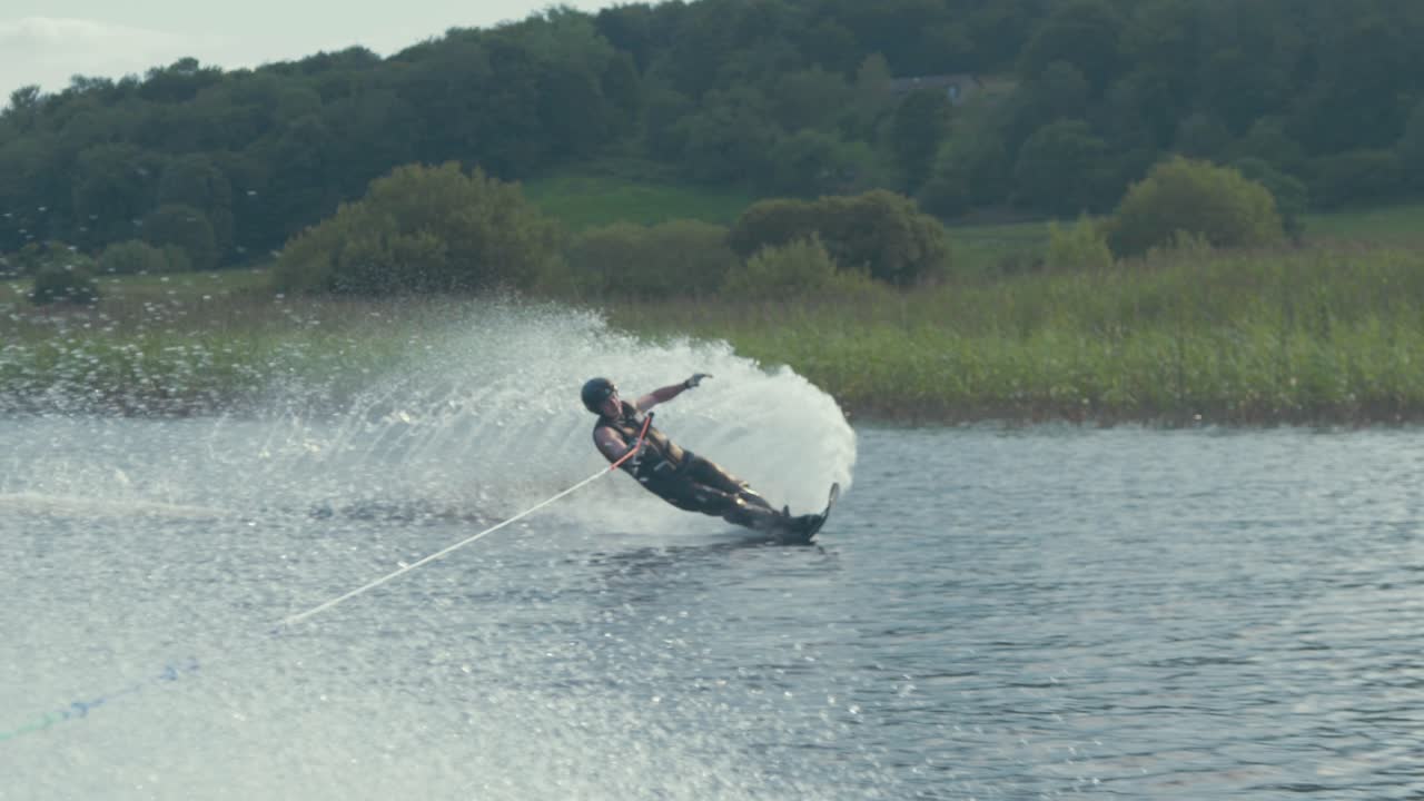 Slalom skier performs clean low turn skiing on river. Slow motion Mid shot