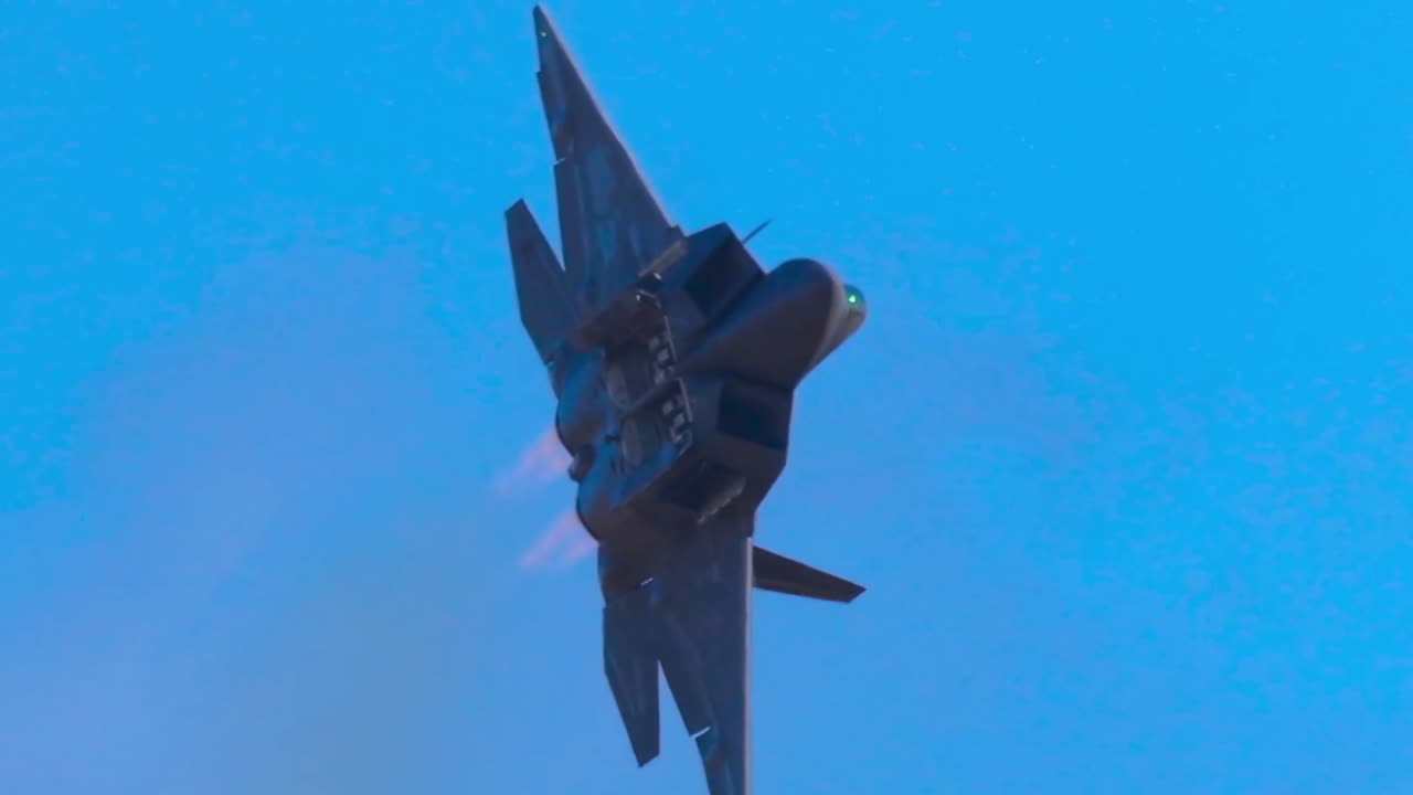 Un caccia militare esegue virate e rotazioni dinamiche su uno sfondo di cielo azzurro